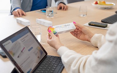 OMNICHROMA Verpackung in Händen einer Mitarbeiterin zu Visualisierung der Stelle Produktspezialist/in / Medizinprodukteberater/in (m/w/d) im Außendienst für den Raum Norddeutschland